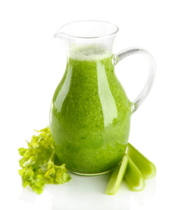 Glass pitcher of celery juice, isolated on white