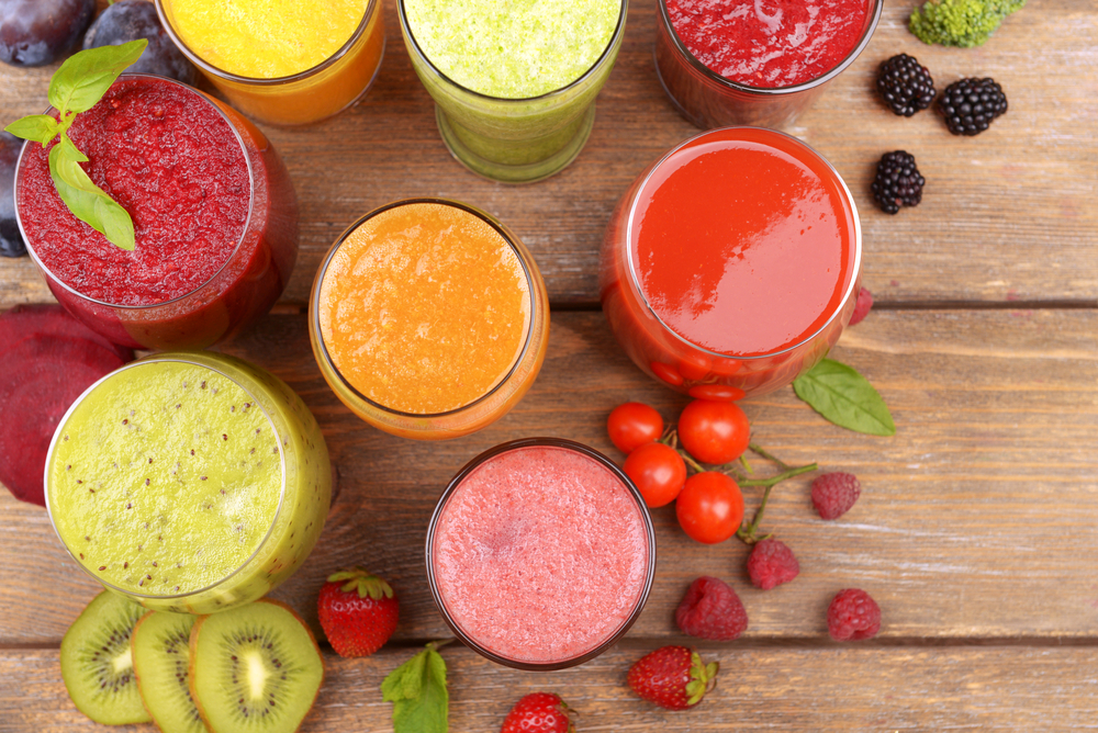 Glasses of tasty fresh juice, on wooden table.